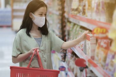 Woman with arms raised standing in store