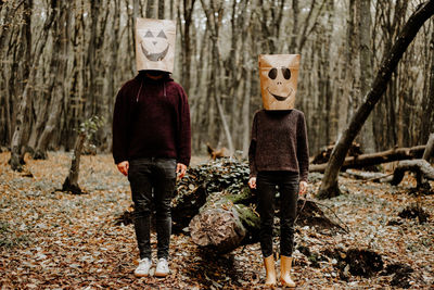 Rear view of two people walking in forest