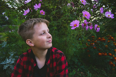 Portrait of cute boy looking at flowering plants