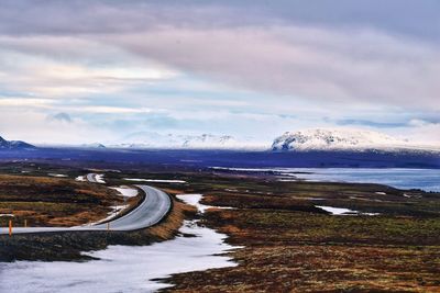 Scenic view of sea by mountains against sky