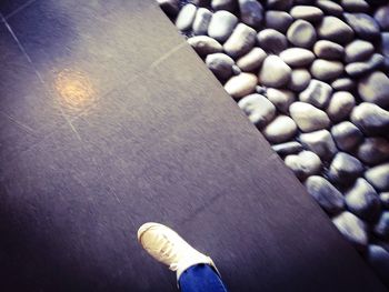 Low section of person standing on tiled floor