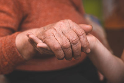 Midsection of woman holding grandmother hand