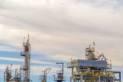 View of factory against cloudy sky