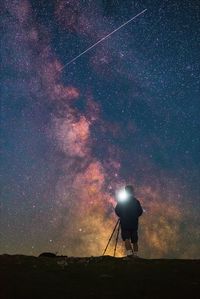 Silhouette man standing against star field at night