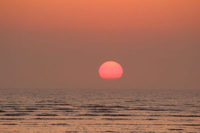 Scenic view of sea against orange sky