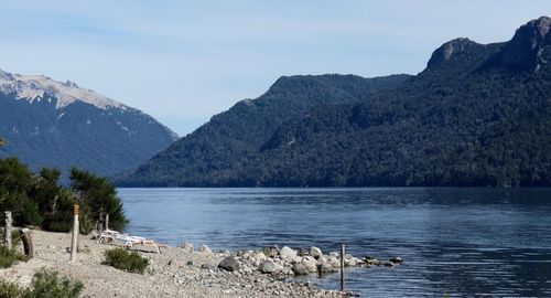 Scenic view of lake by mountains against sky