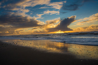 Scenic view of beach against sky during sunset