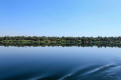 Scenic view of lake against clear blue sky