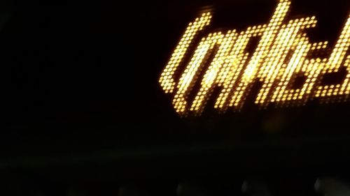 Low angle view of illuminated lighting equipment against sky at night