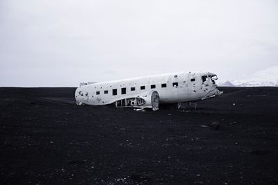 Side view of an abandoned airplane on landscape