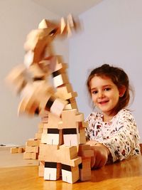 Portrait of girl playing with dominoes at table