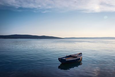 Boat moored on sea against sky