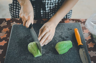 Midsection of man cutting vegetables on table
