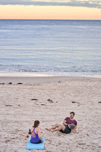 Young friends exercising at beach