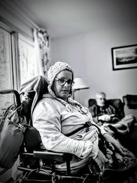 Portrait of my friend in their wheelchair with winter hat and glasses looking serious