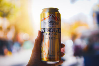 Close-up of hand holding drink against blurred background