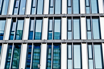 Low angle view of office building against blue sky