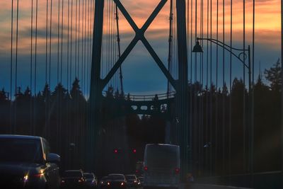 Cars in city against sky during sunset