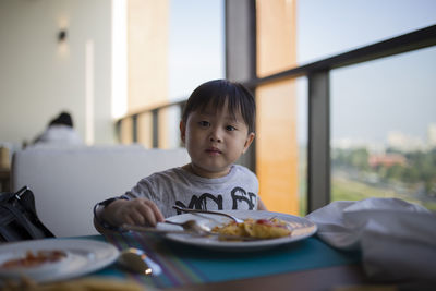 Portrait of boy sitting at table