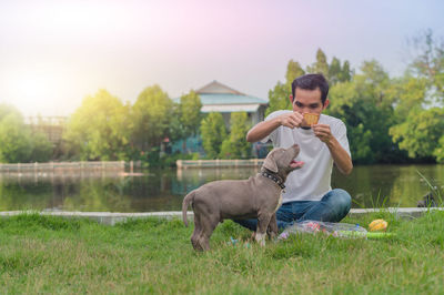 Full length of man with dog on field