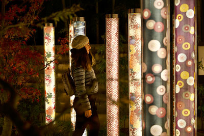 Rear view of woman standing at night