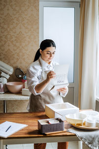 Female baker, pastry chef preparing cake order. arabic asian woman making cake for online delivery