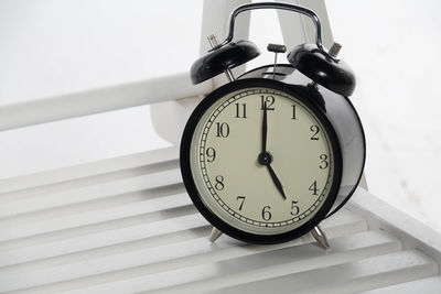 Close-up of alarm clock on table against white background