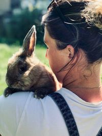 Close-up of woman with rabbit at park