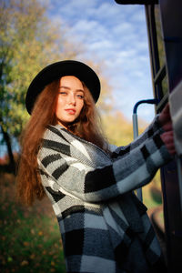 Portrait of a young woman holding a train car