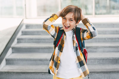 Portrait of smiling girl standing on staircase