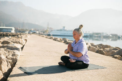 Side view of man sitting on beach