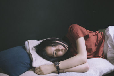 Young woman lying on bed at home