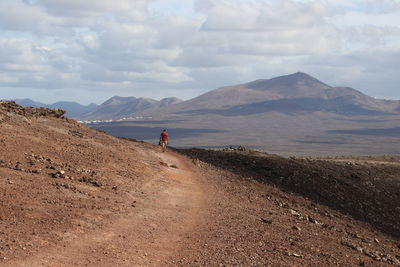 Man standing on mountain against sky