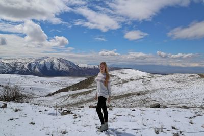 Woman standing on snow against sky