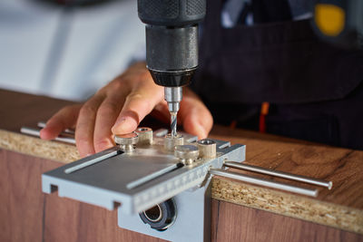 Cropped hand holding sewing machine