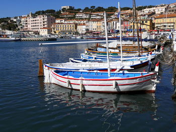 Boats moored in harbor by buildings in city