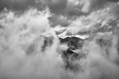 Scenic view of clouds covering mountains against sky