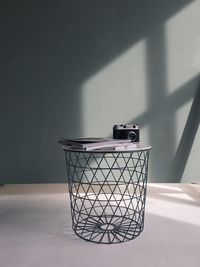 Close-up of garbage can on table against wall