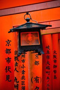 Close-up of lantern hanging against orange building