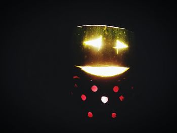 Close-up of lit light bulb at night
