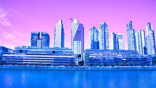 Modern buildings by swimming pool against sky