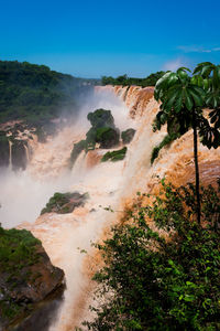 Scenic view of waterfall against sky