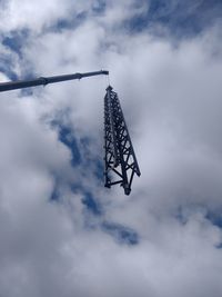 Low angle view of built structure hanging against cloudy sky