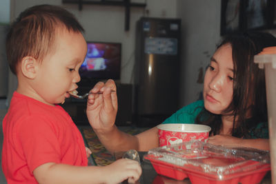 Portrait of a girl having food at home