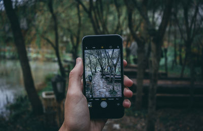 Midsection of person photographing with mobile phone