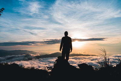 Rear view of silhouette man standing against sky during sunset