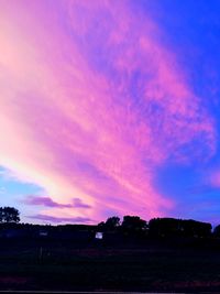 Scenic view of silhouette field against sky at sunset