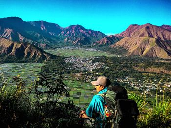 Man looking at mountain range against sky