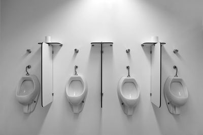 Toilet bowls attached on white wall