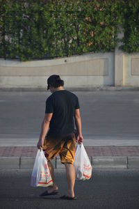 Rear view of woman walking on street in city